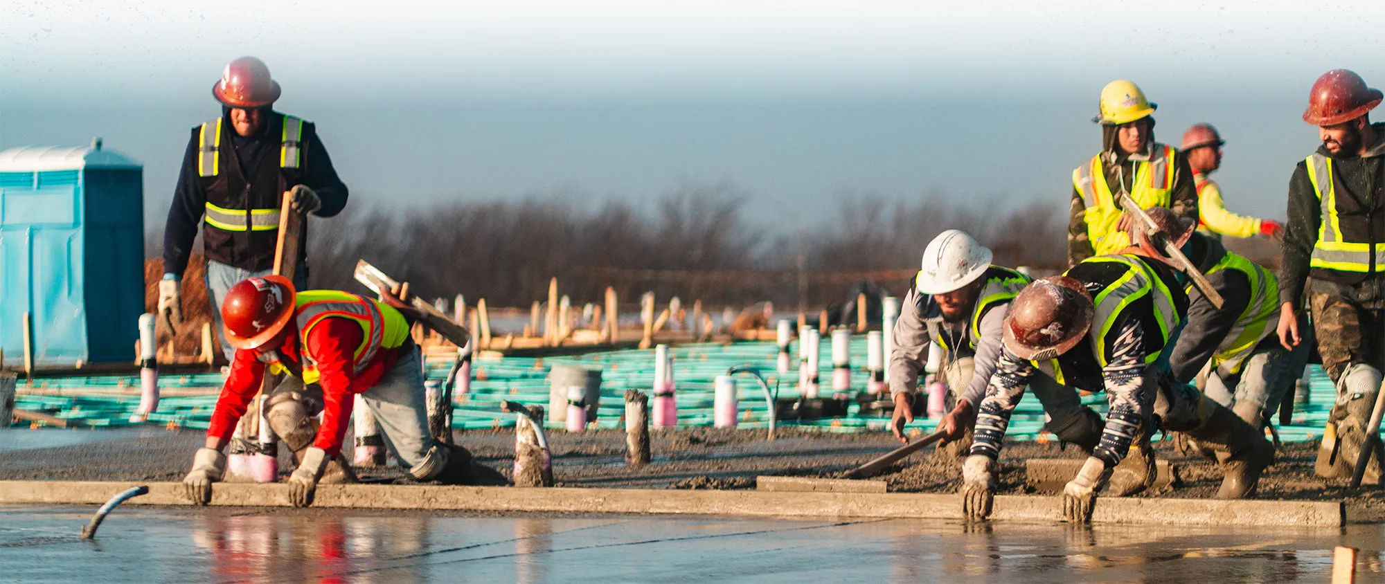 subcontractors pouring concrete at a multifamily construction site