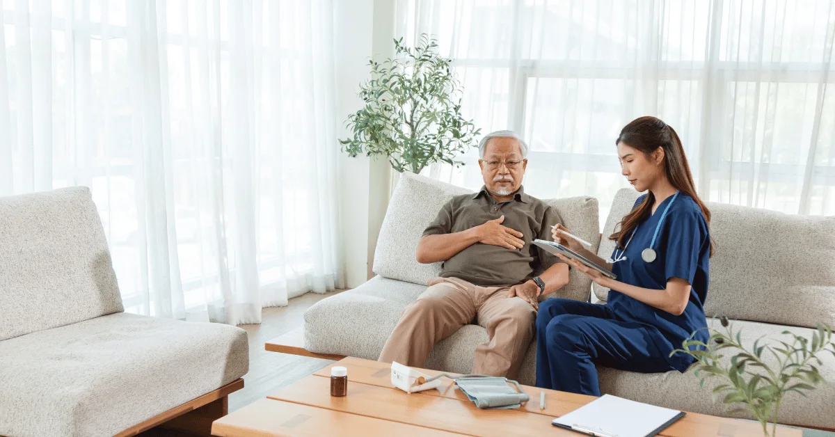 Nurse assessing an elderly patient in a bright, comfortable nursing home room.