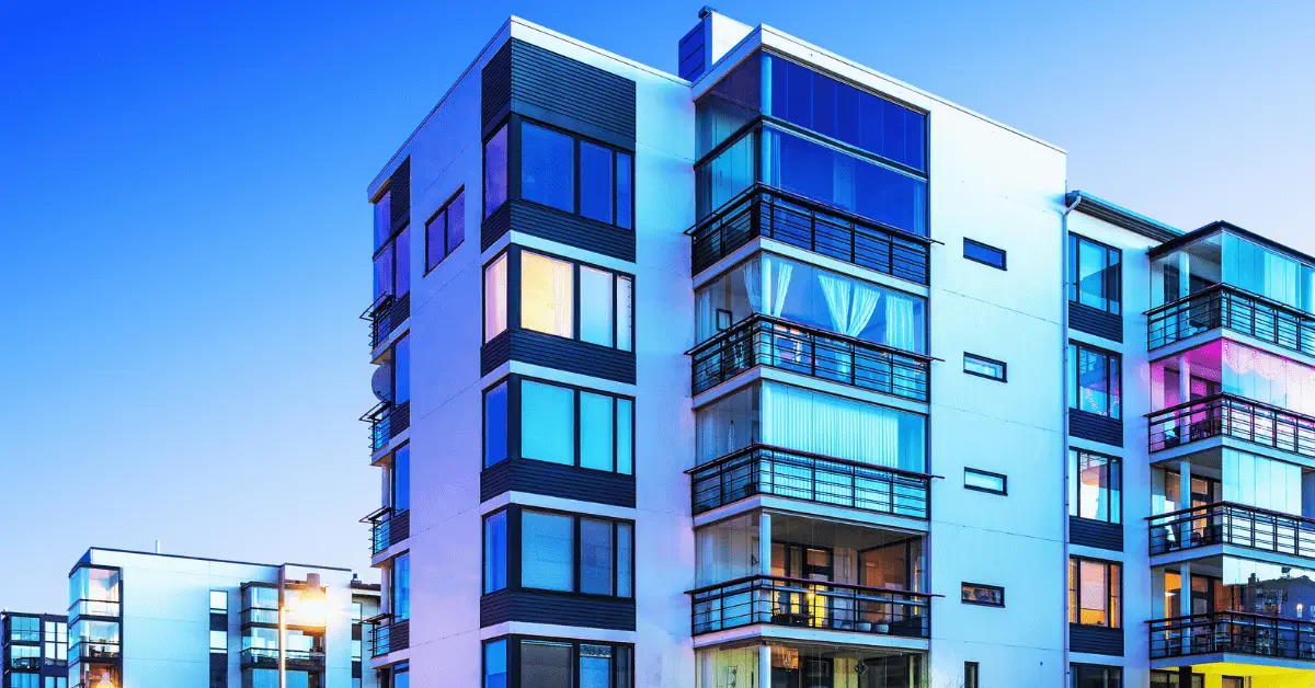 Modern Florida multifamily apartment building with balconies at dusk.